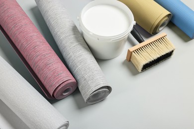 Image of Wallpaper rolls, brush and bucket of glue on light grey background