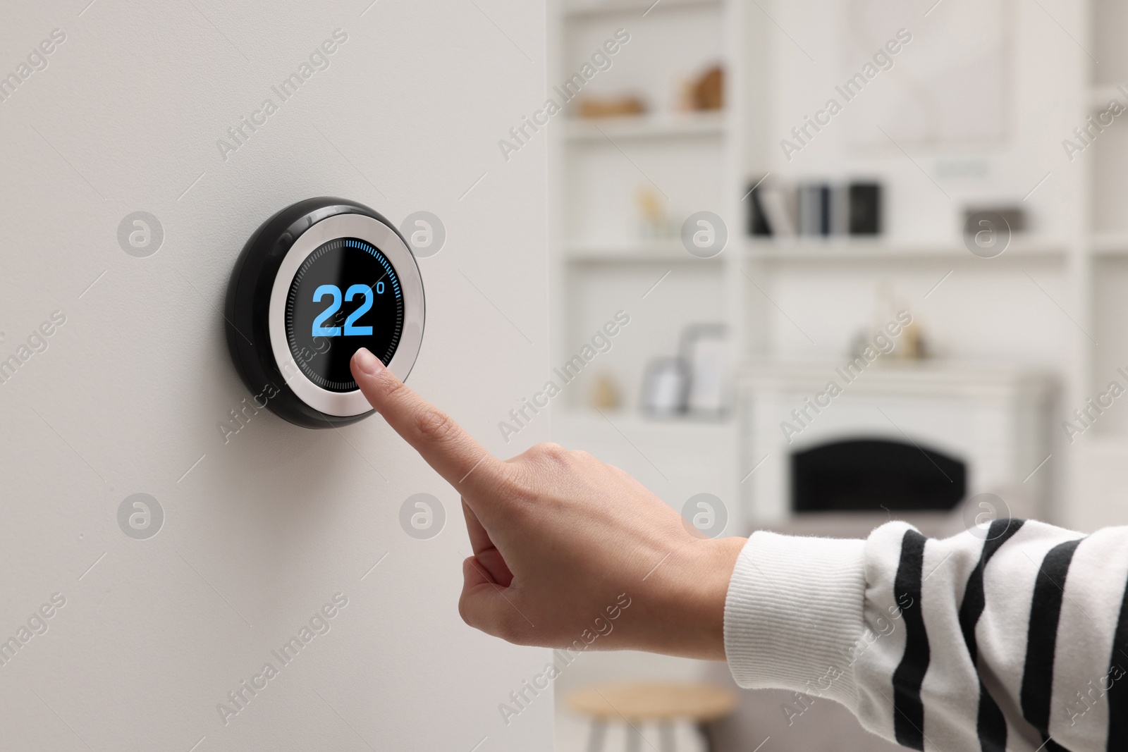 Image of Smart home system. Woman using thermostat indoors, closeup