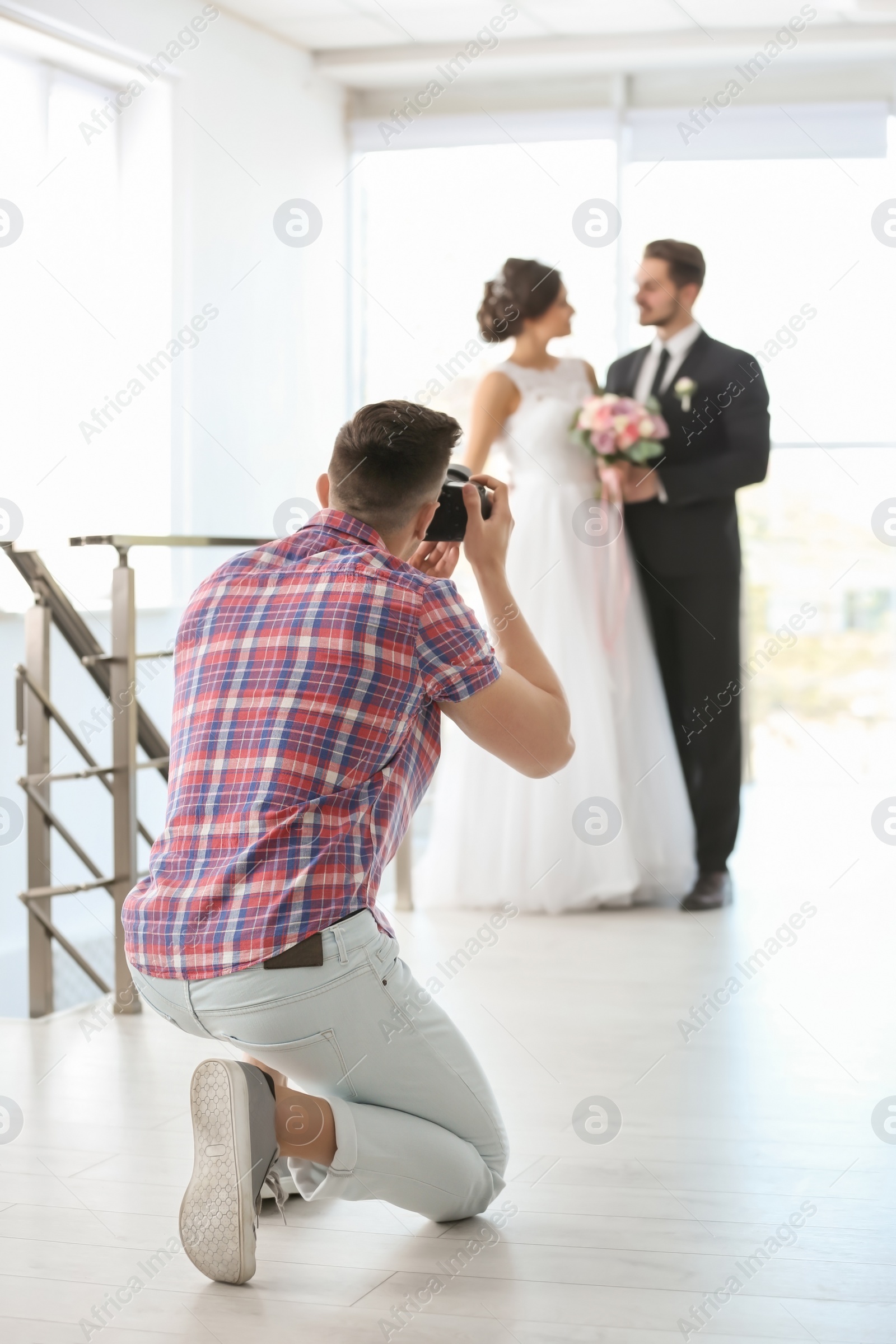 Photo of Professional photographer taking photo of wedding couple in studio