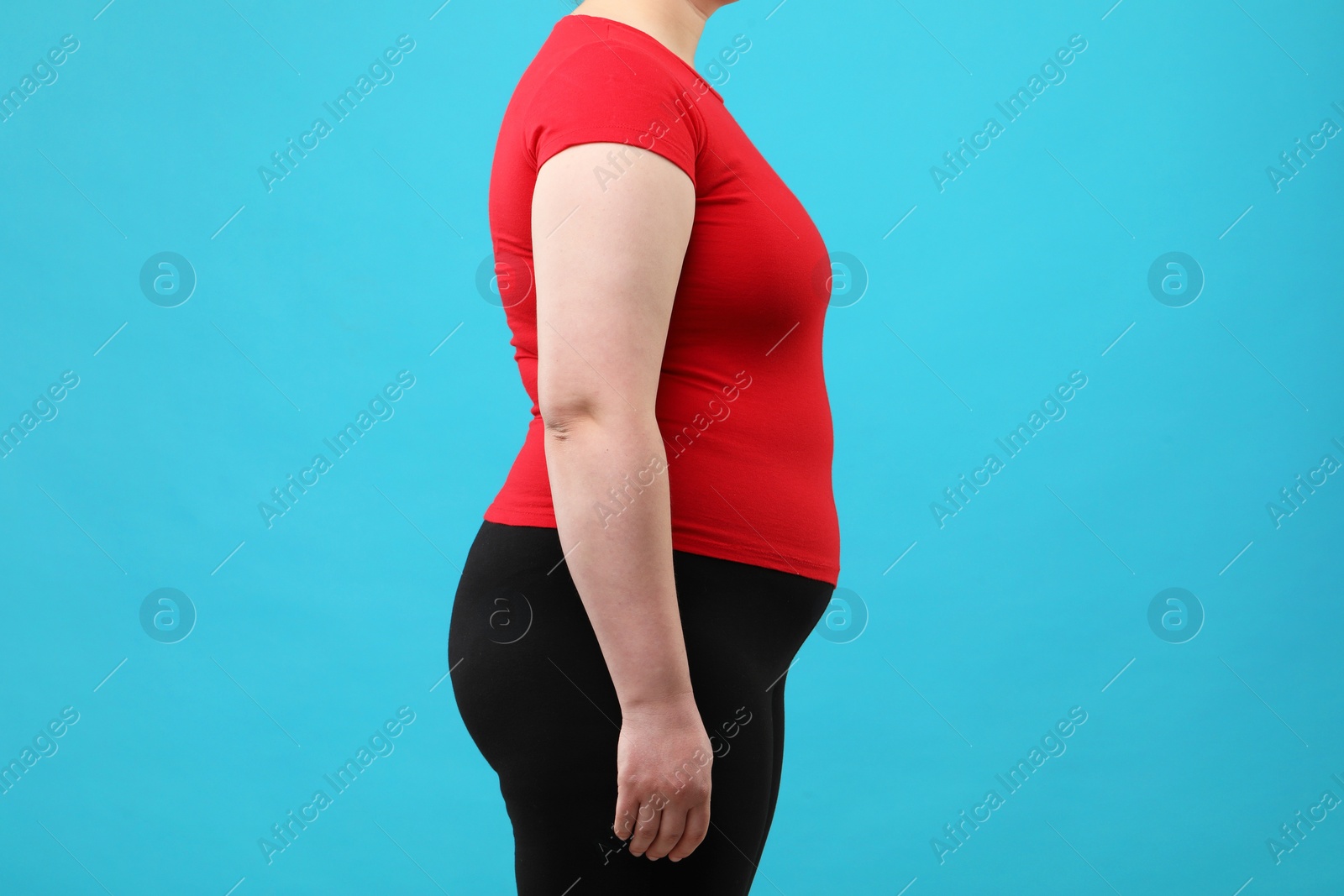 Photo of Overweight woman on light blue background, closeup