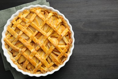 Tasty homemade quince pie on black wooden table, top view. Space for text