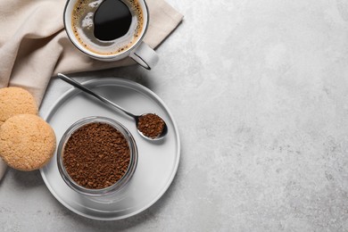 Glass jar of instant coffee, cup with drink and cookies on light table, flat lay. Space for text