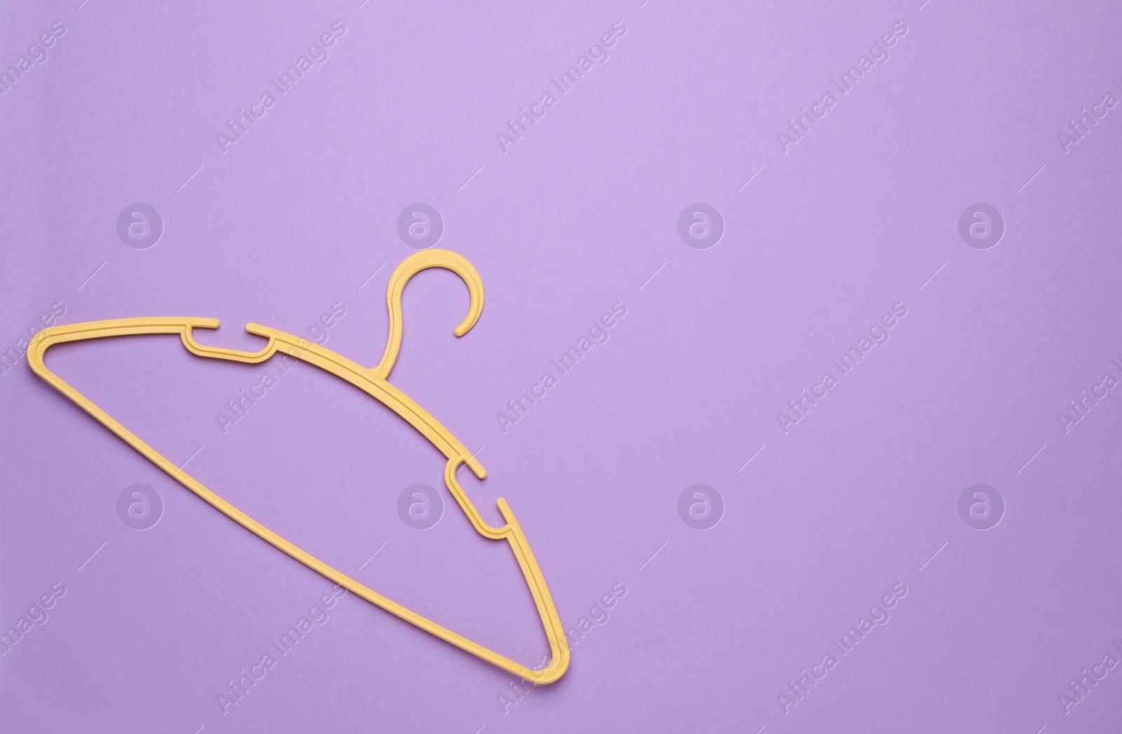 Photo of Empty clothes hanger on violet background, top view. Space for text