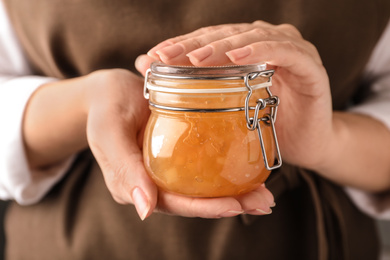 Photo of Woman with jar of delicious jam, closeup