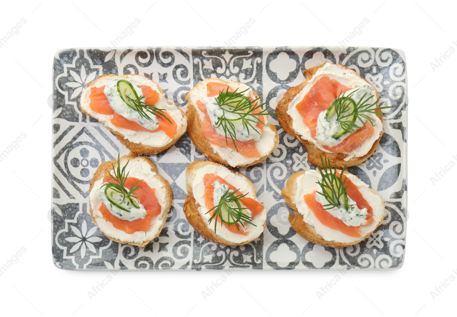 Photo of Tasty canapes with salmon, cucumber, cream cheese and dill isolated on white, top view