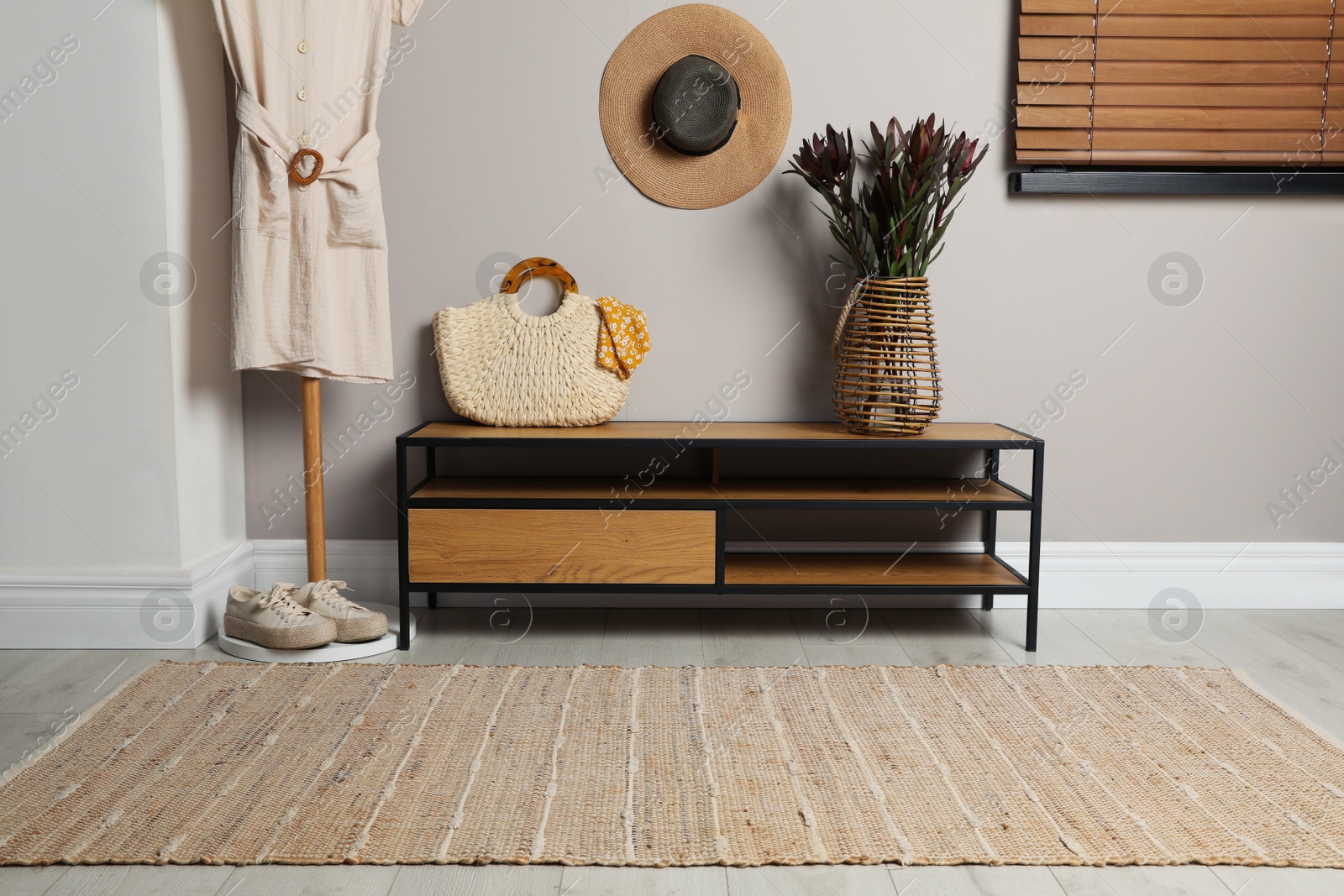 Photo of Stylish striped rug and modern furniture in hallway. Interior design