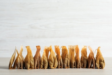 Photo of Many used tea bags on wooden table. Space for text