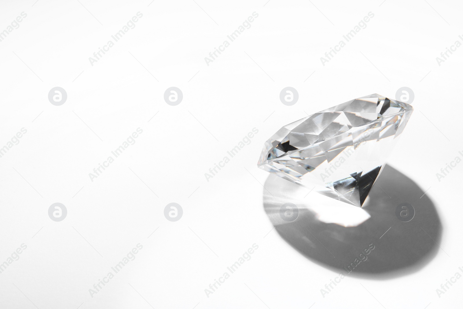 Photo of One beautiful shiny diamond on white background, space for text