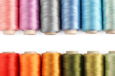 Photo of Set of colorful sewing threads on white background, flat lay. Space for text