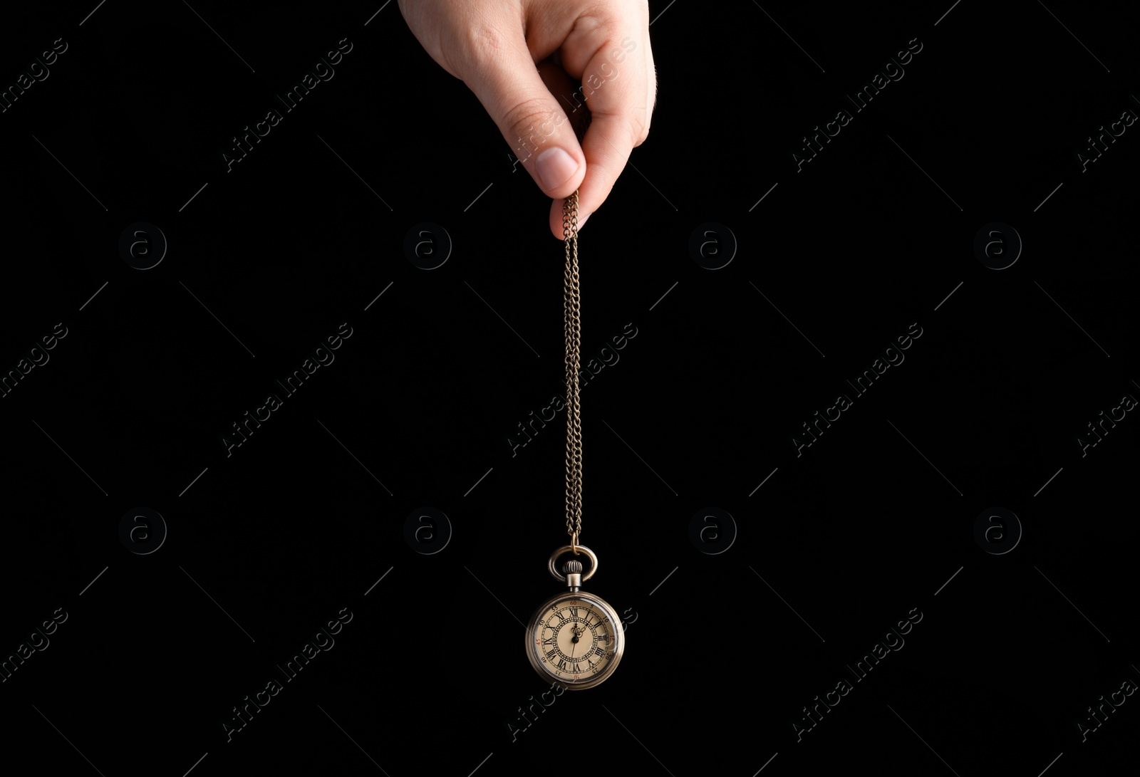 Photo of Psychotherapist with pendulum on black background, closeup. Hypnotherapy session