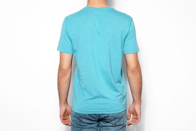 Photo of Young man in t-shirt on light background, closeup. Mock up for design