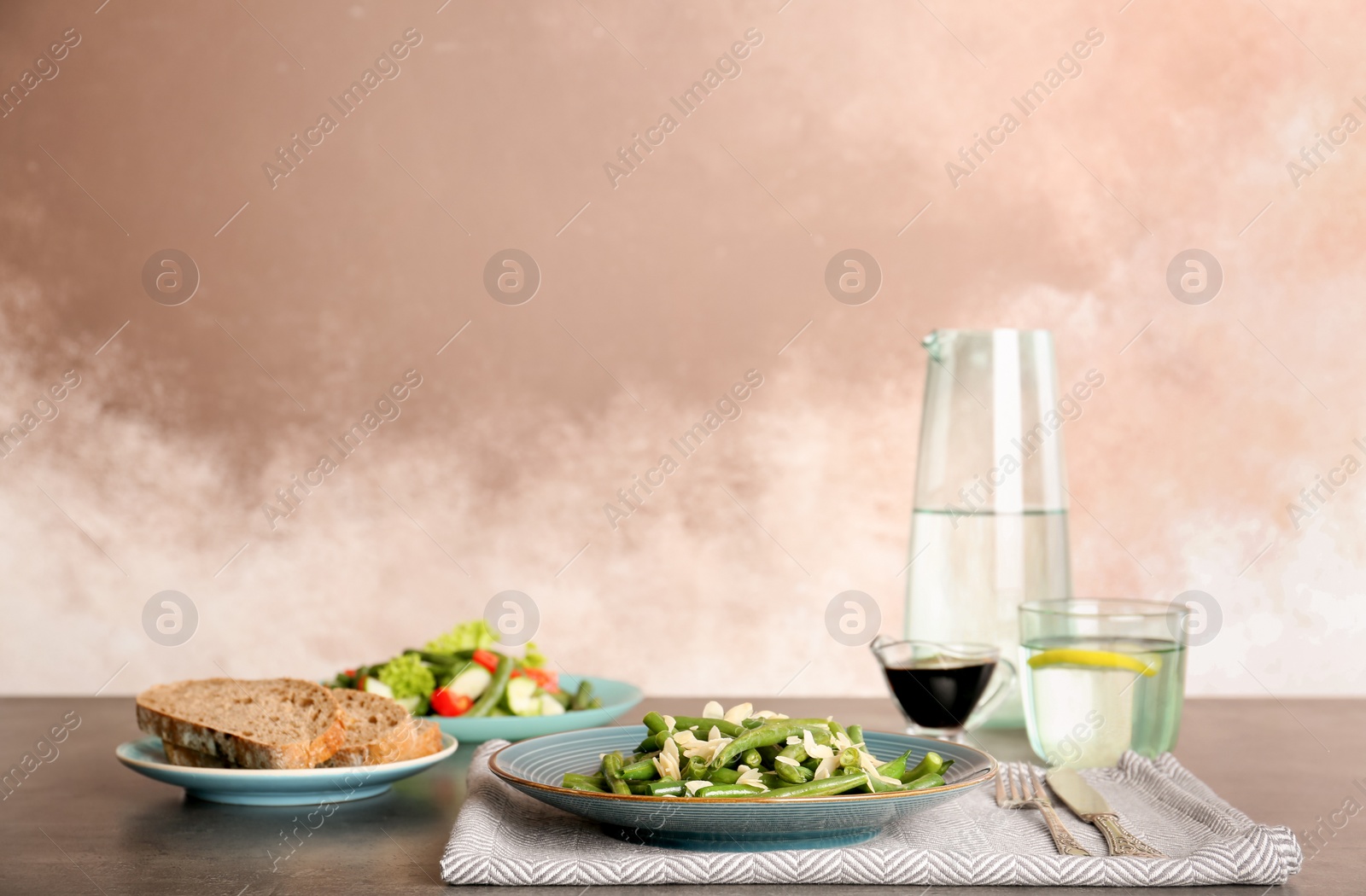 Photo of Plate with tasty green beans and almonds on table