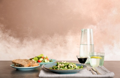 Photo of Plate with tasty green beans and almonds on table