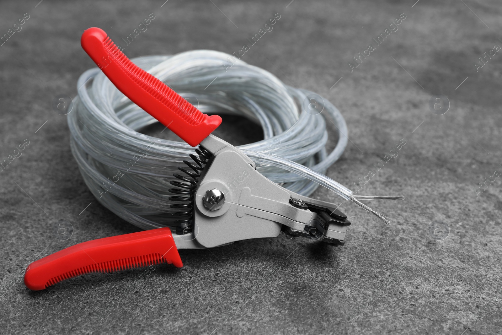 Photo of Cutters and cable with stripped wire on light gray textured table