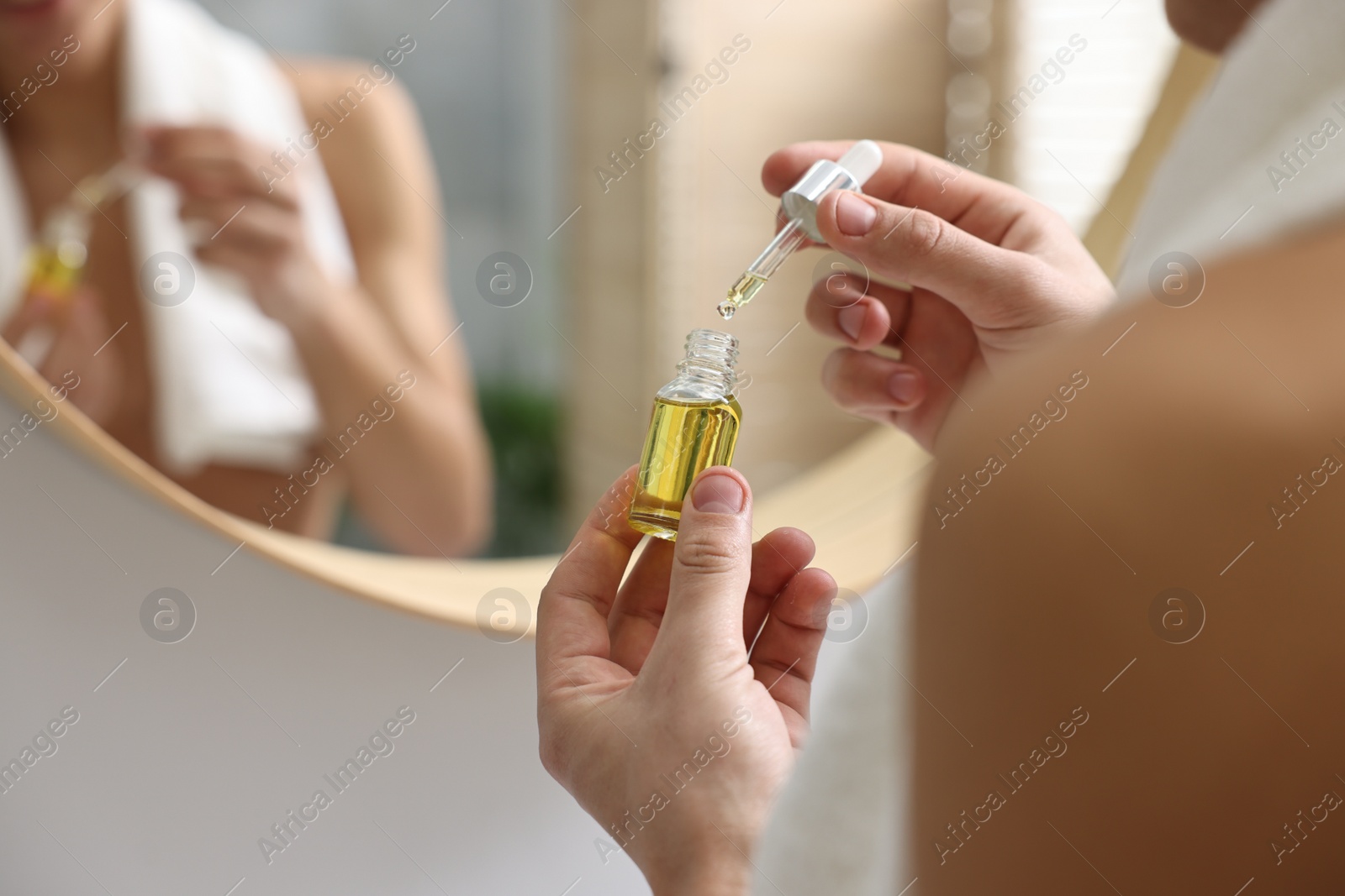 Photo of Man with bottle of serum indoors, closeup view