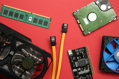Photo of Graphics card and other computer hardware on red background, flat lay