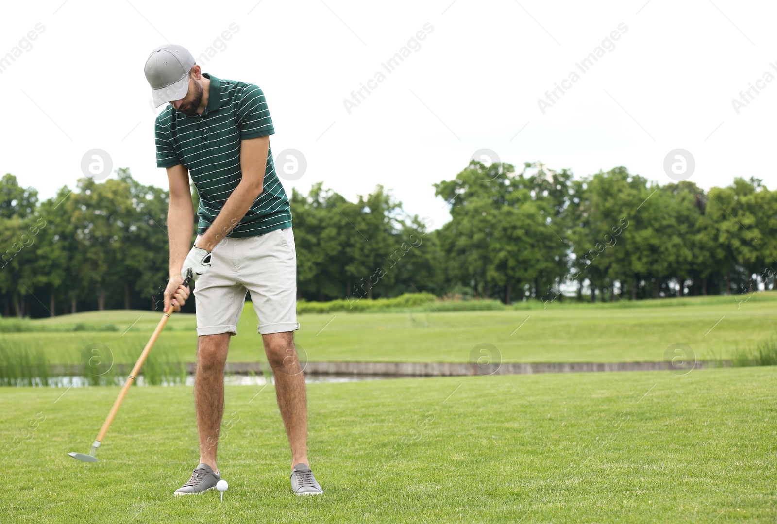 Photo of Man playing golf on green course. Sport and leisure