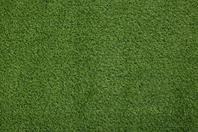 Green artificial grass as background, top view