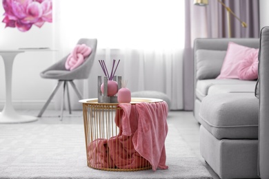 Photo of Side basket table with decor and blanket in modern room interior