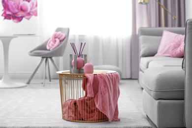 Side basket table with decor and blanket in modern room interior