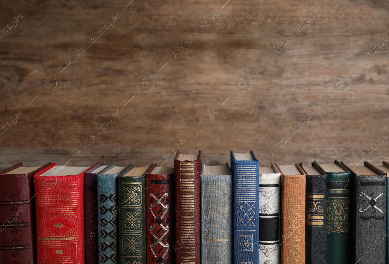 Photo of Stack of hardcover books on wooden background. Space for text