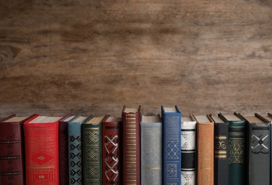 Photo of Stack of hardcover books on wooden background. Space for text