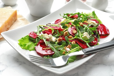 Plate with delicious beet salad served on table