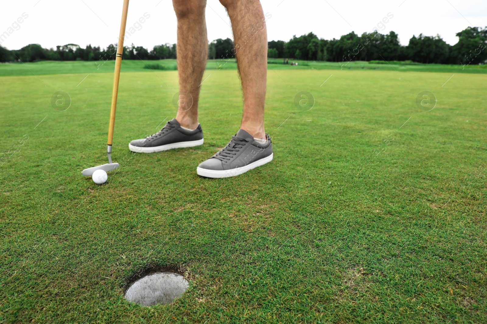 Photo of Man playing golf on green course. Sport and leisure