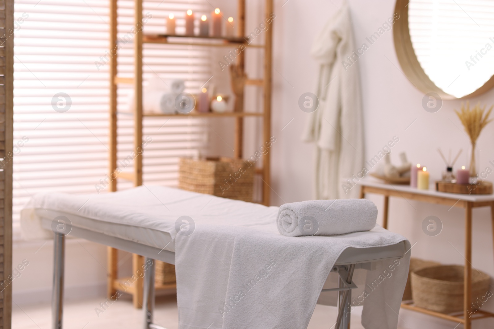 Photo of Comfortable massage table with clean towels in spa center