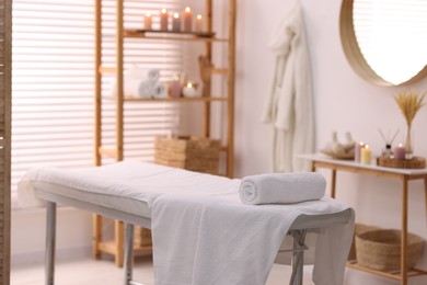 Comfortable massage table with clean towels in spa center