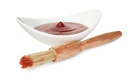 Photo of Tasty barbecue sauce in bowl and brush isolated on white