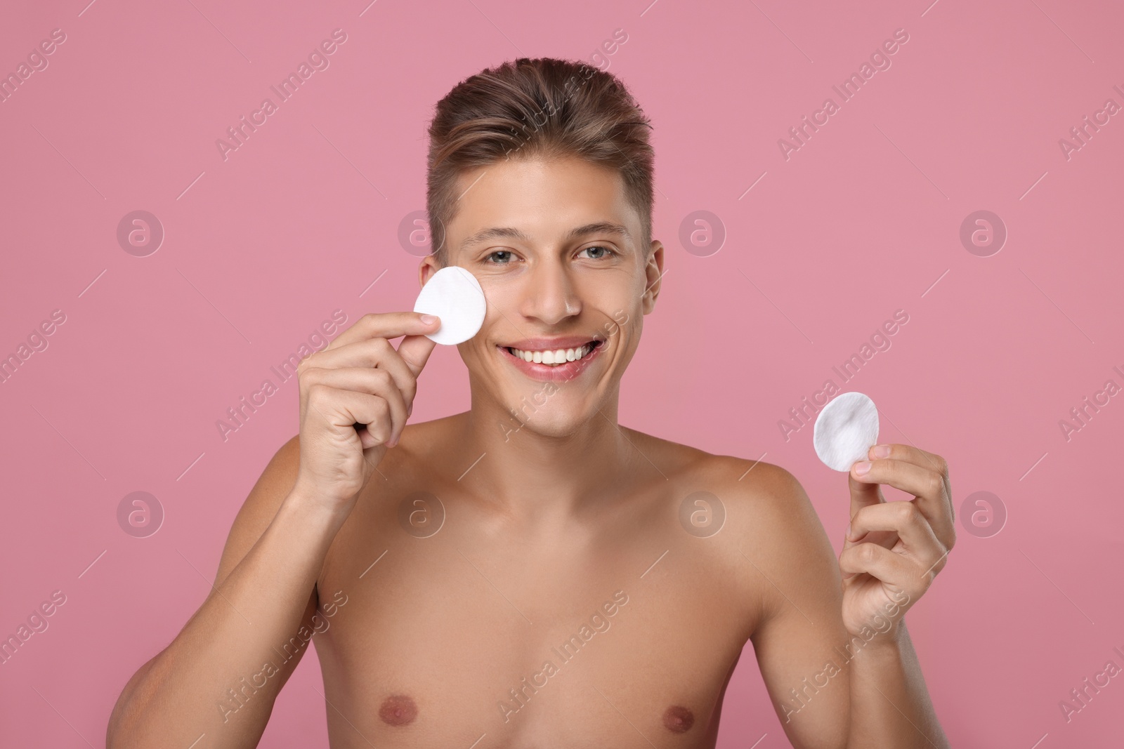 Photo of Handsome man with cotton pads on pink background