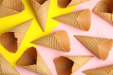 Empty wafer ice cream cones on color background, flat lay
