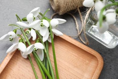 Photo of Beautiful snowdrops on grey table, flat lay