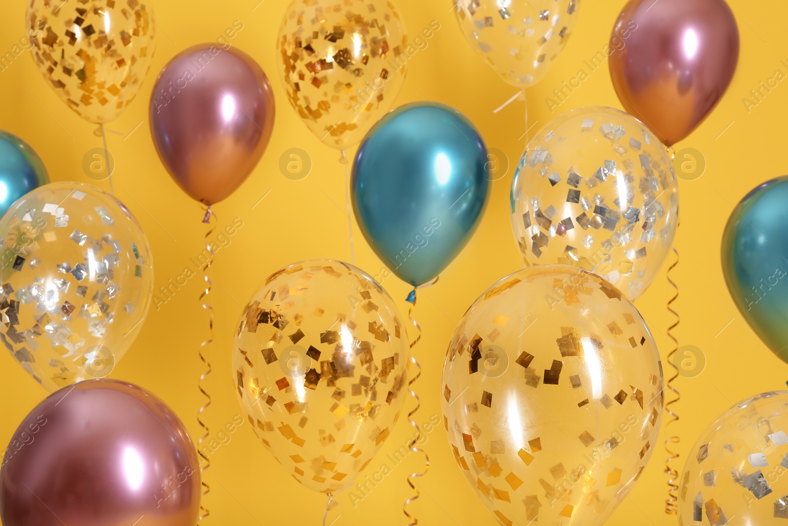 Photo of Bright balloons with ribbons on color background