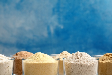 Photo of Bowls with different types of flour on color background. Space for text