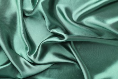 Photo of Crumpled green silk fabric as background, top view