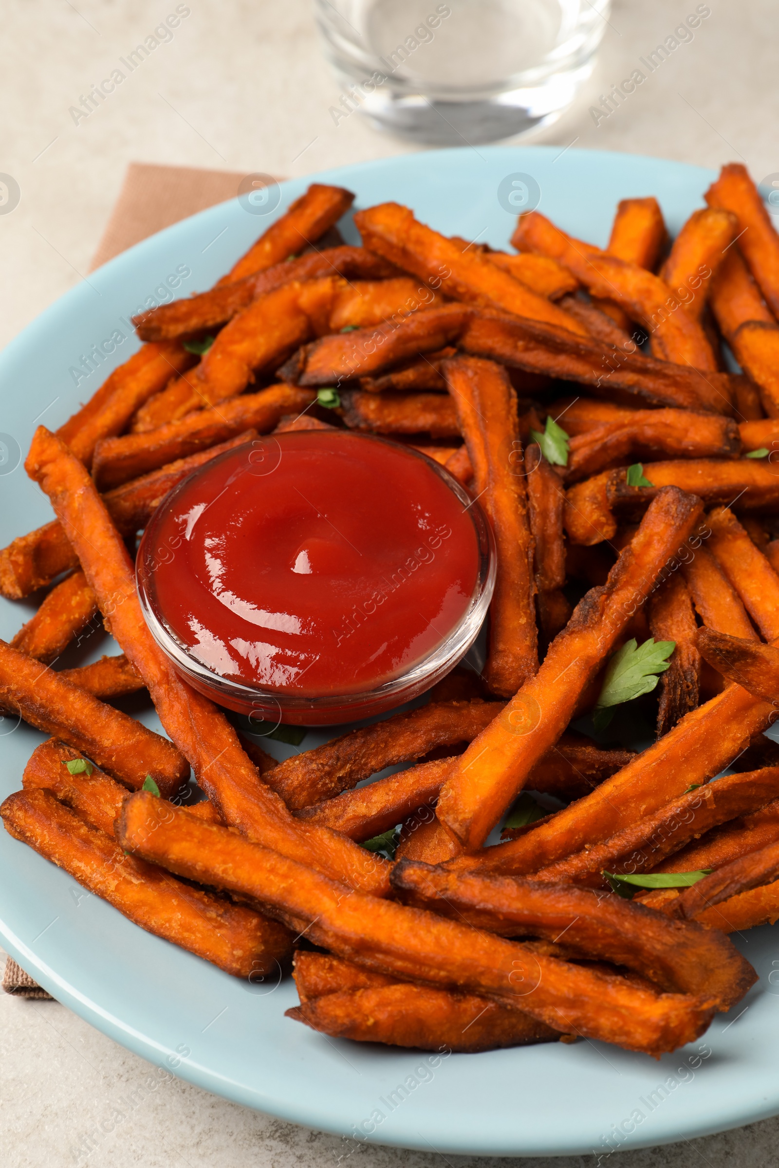 Photo of Delicious sweet potato fries served with sauce on table, closeup