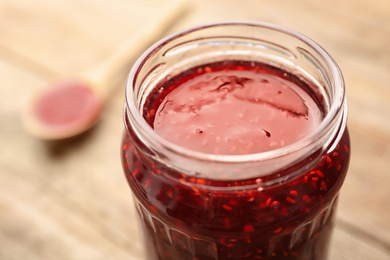 Photo of Homemade delicious raspberry jam on table, closeup