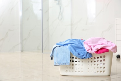 Laundry basket with dirty clothes on floor in room, space for text