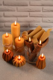 Photo of Beautiful burning beeswax candles on light textured table