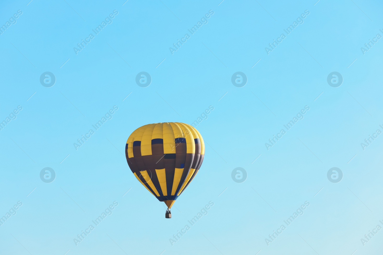 Photo of Colorful hot air balloon flying in blue sky. Space for text