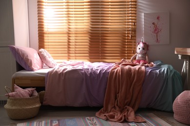 Bed with beautiful linens in children's room. Modern interior design