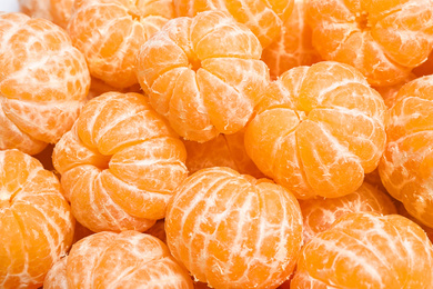 Peeled fresh ripe tangerines as background, closeup