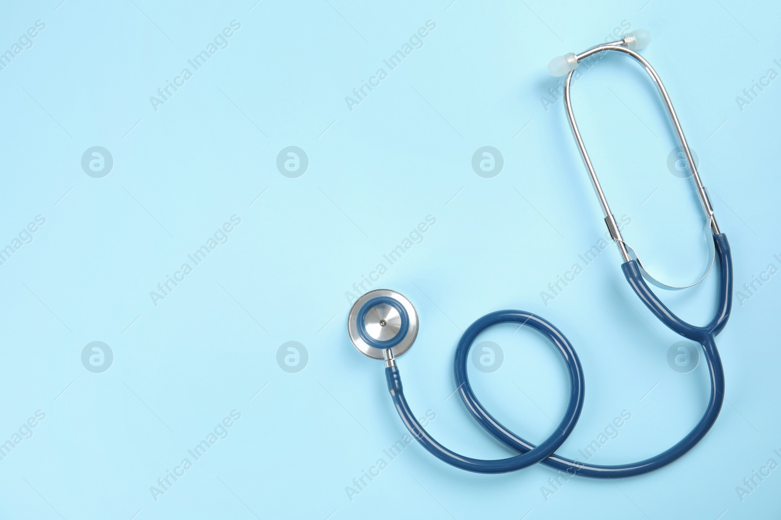 Photo of Stethoscope with space for text on color background, top view. Medical tool