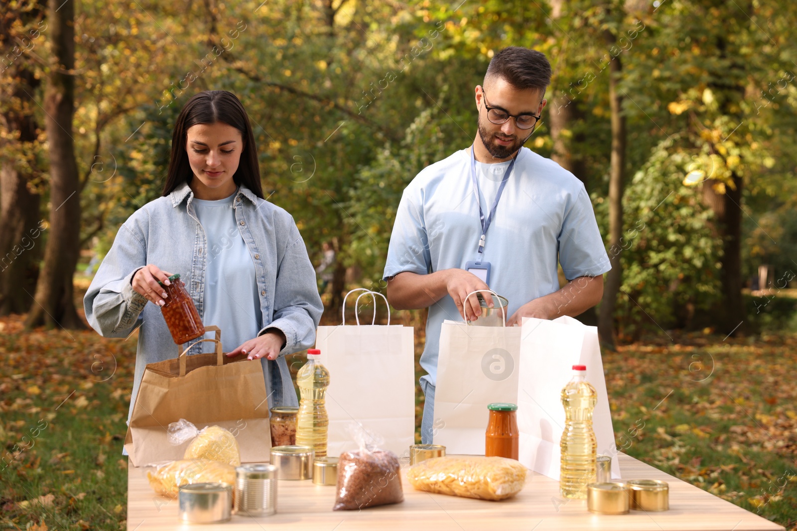 Photo of Volunteers packing food products at table in park