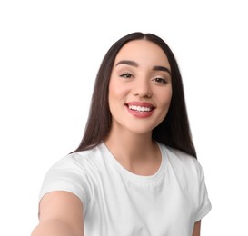 Smiling young woman taking selfie on white background