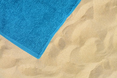 Soft blue beach towel on sand, top view. Space for text