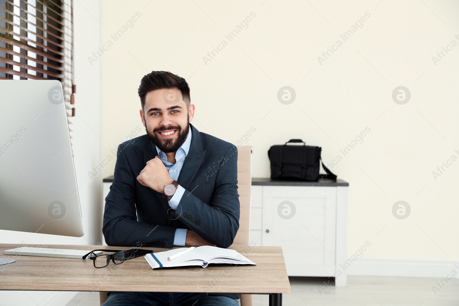 Photo of Handsome businessman working at table in office