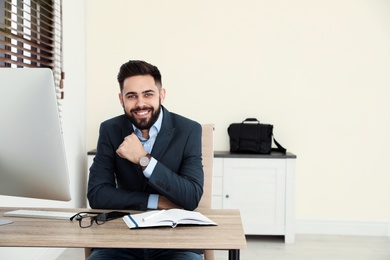 Photo of Handsome businessman working at table in office